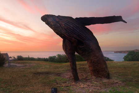 BONDI, AUSTRALIA - OCTOBER 23, 2014; Sculpture by the Sea .  Sculpture titled Breaching by Michael Greve, VIC, against a spectacular beautiful sunrise sky at Bondi.  Made from redgum, spotted gum timbersのeditorial素材