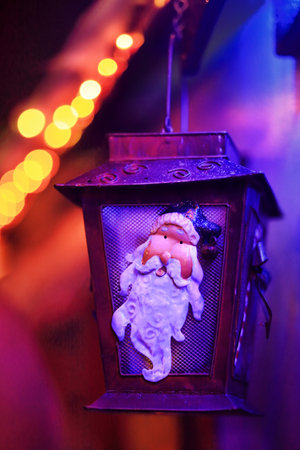 QUAKERS HILL, AUSTRALIA - DECEMBER 24 2014;  Closeup of tin lantern with Santa seasonal image decoration on house amidst glow of festive coloured twinkling led lights at Christmas timeのeditorial素材