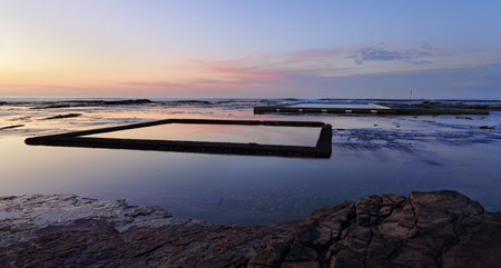 Two ocean rockpools and reflections at sunrise.  Coledale NSW Australiaの写真素材
