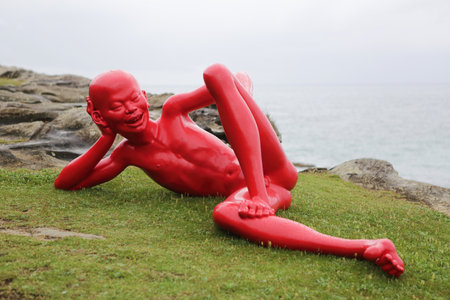 BONDI, AUSTRALIA - OCTOBER 22, 2015;  Annual Sculpture by the Sea free public event.  Exhibit titled harbour by Chen Wenline, a glossy painted bronze figure with cheeky expression and poseのeditorial素材