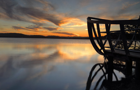 Magnificent summer sunset from Kincumber looking across the Kincumber broadwaters to  Davistown.  The shipbuilders wharf silhouetted on the right.  Kincumber has a rich history of boat building and shipwrights and this jetty is a reminder of that.の写真素材