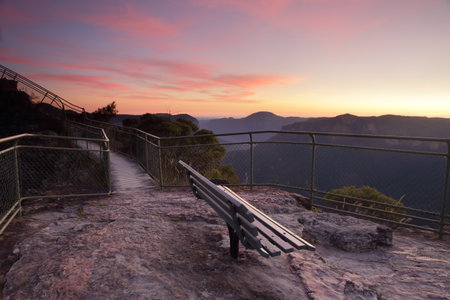 Spectacular dawn skies overhead with views from Pulpit Rock, Blackheath, stunning scenery and views overlooking the Grose Valley with Mount Baniks directly ahead in the far distance. This seat awaits you!の写真素材
