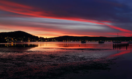 Lingering colour in the evening skies over Yattalunga and reflections in the tidal estruary.  A long exposure with some motion の写真素材
