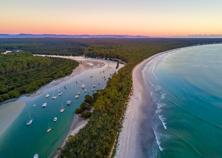 Scenic coastal landscape beautiful beach and inlet with moored yachts and boats.  Morning sky at dawn with soft light.  Australiaの写真素材
