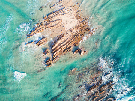 Rocks being swallowed up by ocean as tide surges inの写真素材