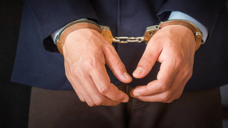 close up hands in handcuffs,arrested businessman.の写真素材
