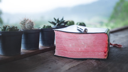 Close up red Bible in morning on wooden table. Christian concept.の写真素材