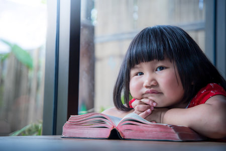 Little girl read the bible and pray at home, child's pure faithの写真素材