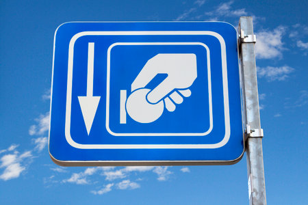 Blue metal pay here parking signal with sky backgroundの写真素材
