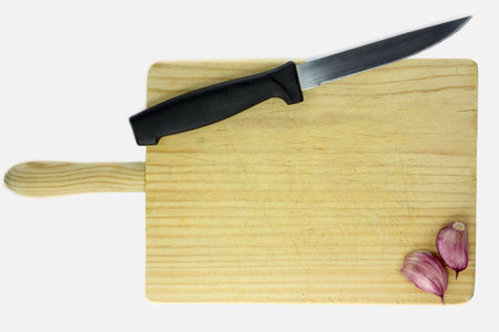 Wooden cutting board with knife, garlics, and text space, isolated with white backgroundの写真素材