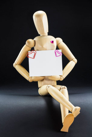 Portrain of a sitting woman mannequin holding an empty cardの写真素材