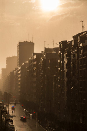 Gloomy city street during a downpour at sunsetの写真素材