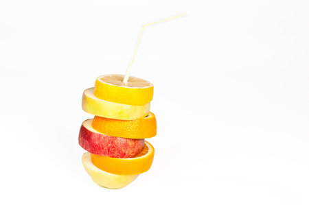 Stack of orange, lemon, pear and apple slices with straw juice concept isolated on whiteの写真素材