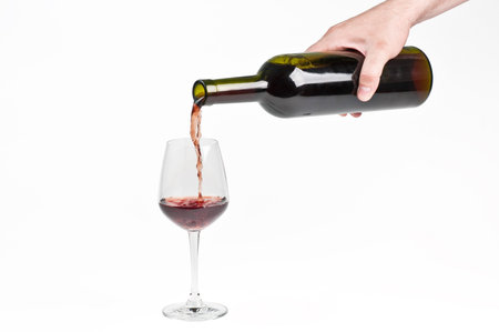 Red wine being poured into wine glassの写真素材