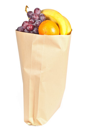 Fruits in brown grocery bag isolated on white backgroundの写真素材