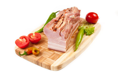 Arrangement with meat smoked bacon, tomatoes and pepper on cutting boardの写真素材