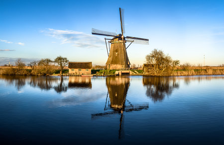 Kinderdijk, Rotterdam, Netherlands - December 22, 2013:  Windmill reflecting in water at sunset.