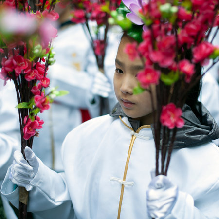Paris, France - February 17, 2013:  Chinese girl holding red flowers at the Lunar New Year Festival.のeditorial素材