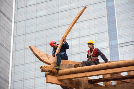 Chengdu, Sichuan Province, China - Nov 13, 2015: Chinese carpenters building a temple at the Daci monastery surrounded by modern skyscrapers in the center of the city.のeditorial素材
