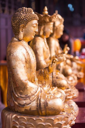 Chengdu, Sichuan Province, China - December 2,2015 : three gold colored buddha statues at the entry of DaCi buddhist temple in the center of the city.のeditorial素材