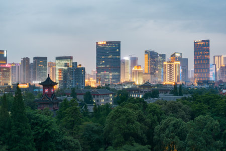 Chengdu, Sichuan Province, China - June 1, 2016:  Clock tower among trees with Skyline in the background at nightのeditorial素材