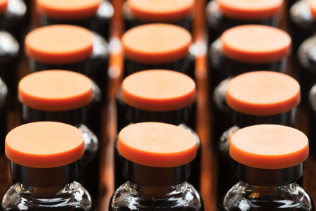 row of medicine ampules with orange cap close-upの写真素材