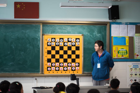 Teacher giving a chess lesson to children in a chinese classroomのeditorial素材