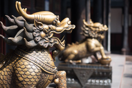 Two bronze dragon scultures at the entrance of a buddhist temple