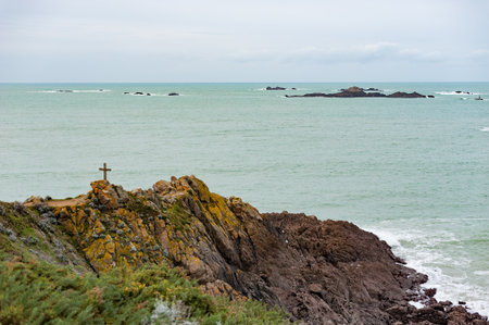 Brittany seascape with a cross on rocks and cloudsの写真素材
