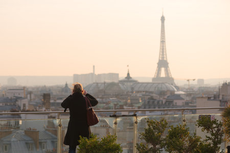 Woman taking the Eiffel tower in photoのeditorial素材