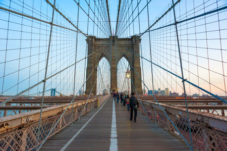 People walking on the Brooklyn bridge at duskのeditorial素材