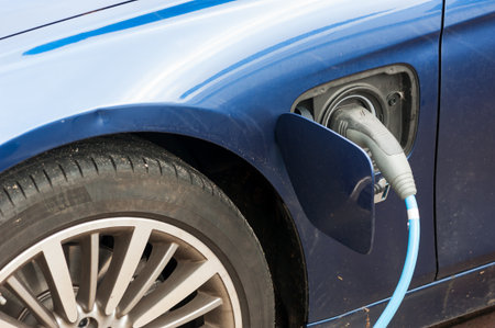charging blue electrical car close-up with plug cable