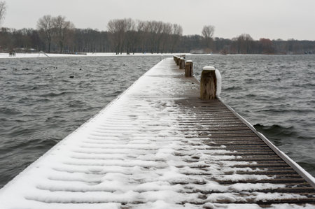 Floating wooden bridge on a lake under the snowの写真素材