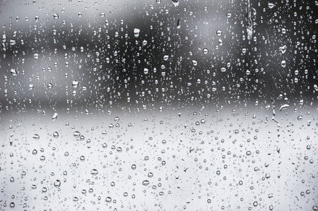 Water drops on a window with a black and white backgroundの写真素材