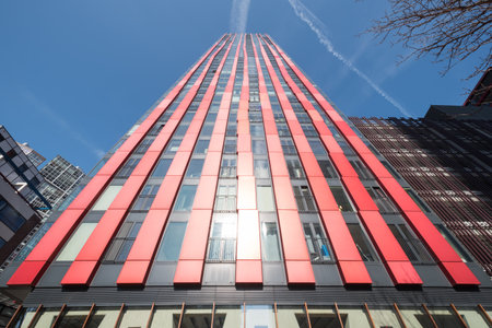 Rotterdam, Netherlands - March 26, 2016 : red apple building against blue sky vertical low angle view.のeditorial素材