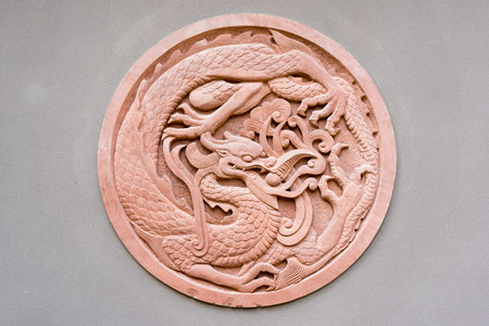 Red circular dragon bas-relief on a grey wall, Chinaの写真素材