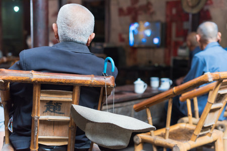 Senior chinese people watching TV in an old tearoomのeditorial素材