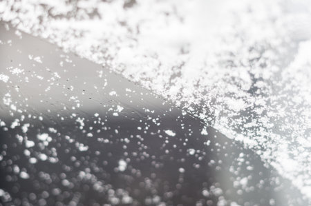 Snow on a cars front windshield selective focusの写真素材