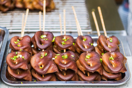 Pig grilled snouts skewers in a street market in Chinaの写真素材