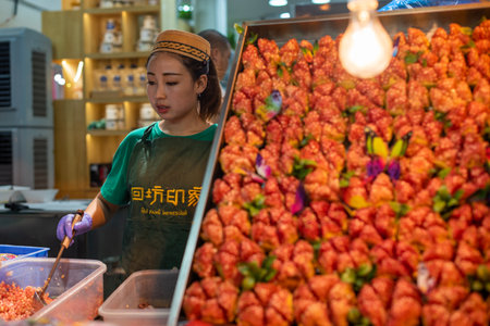 Xian, Shaaxi province, China - Aug 10, 2018 : Woman selling pomegranate in a muslim suburb street marketのeditorial素材
