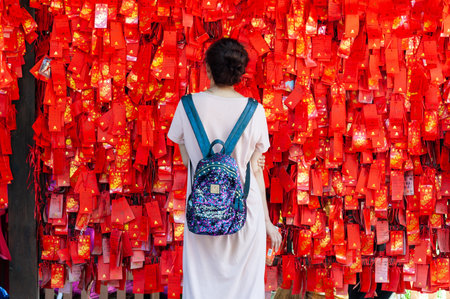 Xian, Shaanxi province, China - Aug 10, 2018 : Woman looking at wishes red ribbons in XiaoYanTa temple in Xianのeditorial素材