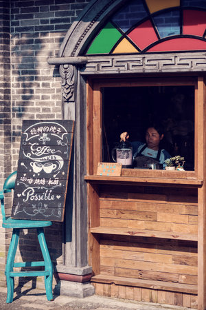Anren, Sichuan province, China - Aug 26, 2018 : Woman preparing a smoothie in a street coffee in the old towのeditorial素材
