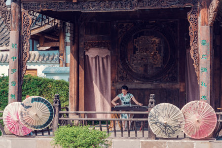 Anren, Sichuan province, China - Aug 26, 2018 : Woman playing Guzheng traditional chinese music string instrumentのeditorial素材