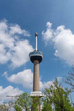 Rotterdam, Netherlands - April 29, 2019 : Euromast tower against blue sky and white sky low angle...