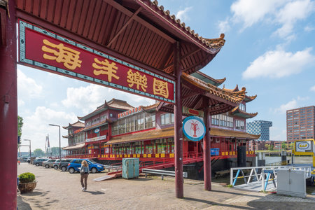 Rotterdam, Netherlands - April 29, 2019 : Sea park written in chinese on a chinese gate leading to a chinese pagoda style hotel restaurant boat in Rotterdamのeditorial素材