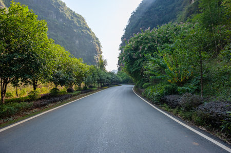 Empty road with karst hills in the background in Yangshuo, Guilin, Guangxi province, Chinaの写真素材