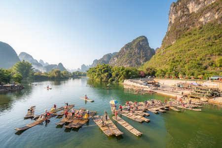 Yangshuo, Guilin, Guangxi province, China - Nov 9, 2019 : Tourist bamboo rafts arriving at the end of the tour on the river with karst limestone hills and blue sky in the background.のeditorial素材