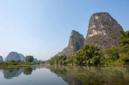 Lake with limestone karst hills foggy landscape reflecting in the river in Yangshuo, Guangxi province, Chinaの写真素材
