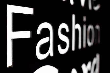 Fashion word in illuminated letter on a black background close-up viewの写真素材