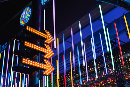 Colorful neon lights with arrow signs at night low angle view background